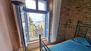 Una camera da letto con una grande finestra, un letto e un termosifone.