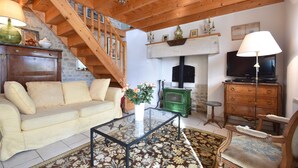 Ein Wohnzimmer mit Sofa, Couchtisch und Kamin.