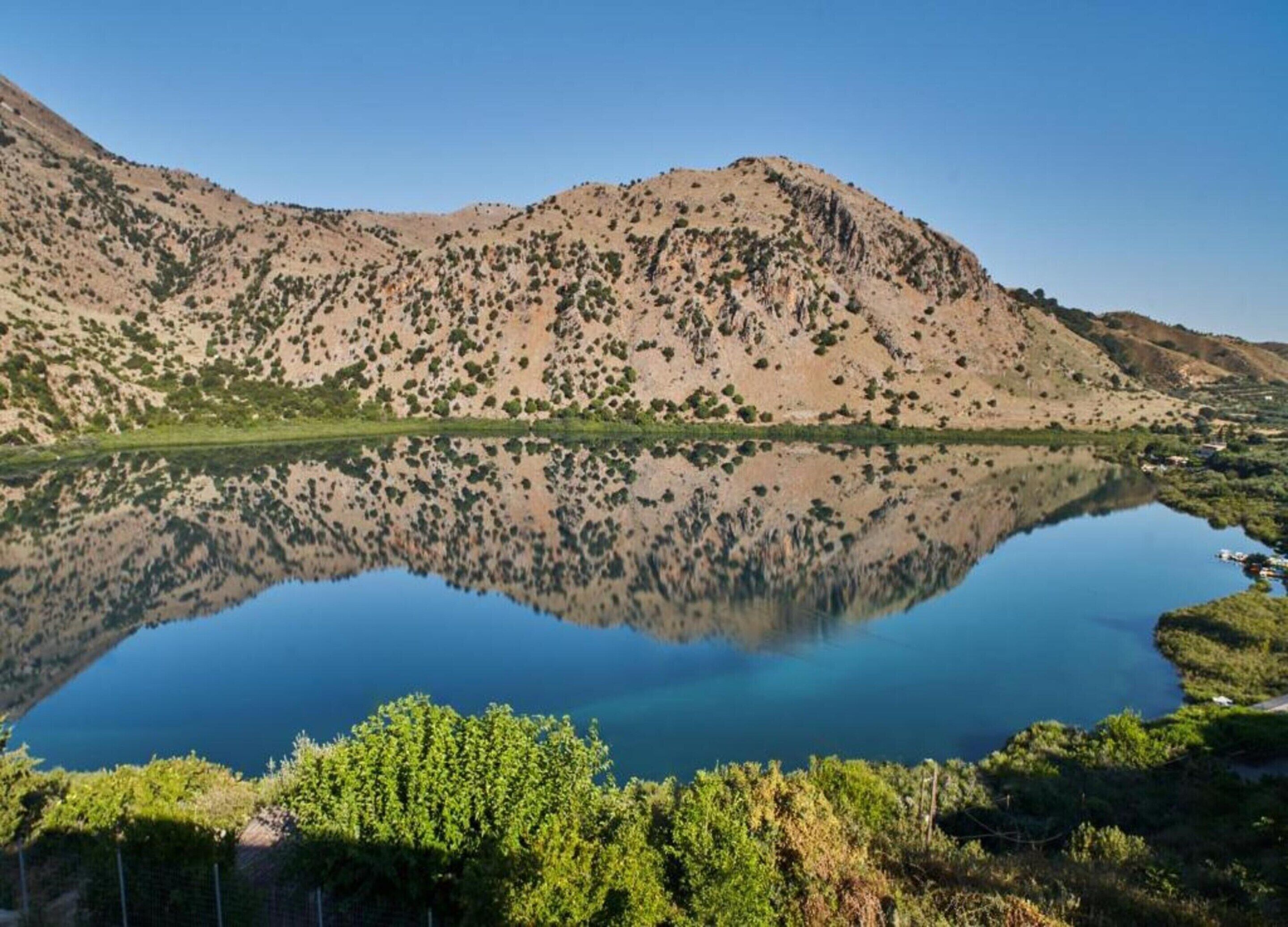 A mountainous landscape with a calm lake reflecting the terrain.