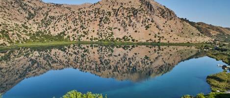 A mountainous landscape with a calm lake reflecting the terrain.
