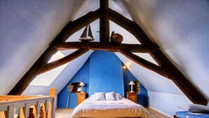 A bedroom with a sloped ceiling, a bed, a dresser, and a small table with a lamp. - Alluring Holiday Home With Fenced Garden, Barbecue (Montaigu-les-Bois)