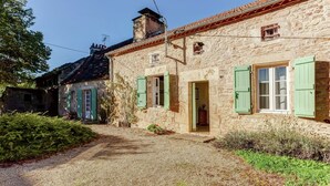 A stone building with green shutters, a gravel path, and a small garden. - Forest Hideaway in Saint-caprais (Saint-Caprais)