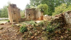 The ruins of a stone building with partially standing walls and overgrown vegetation. - Saint-germain Beach Bliss (Saint-Germain-sur-Ay)