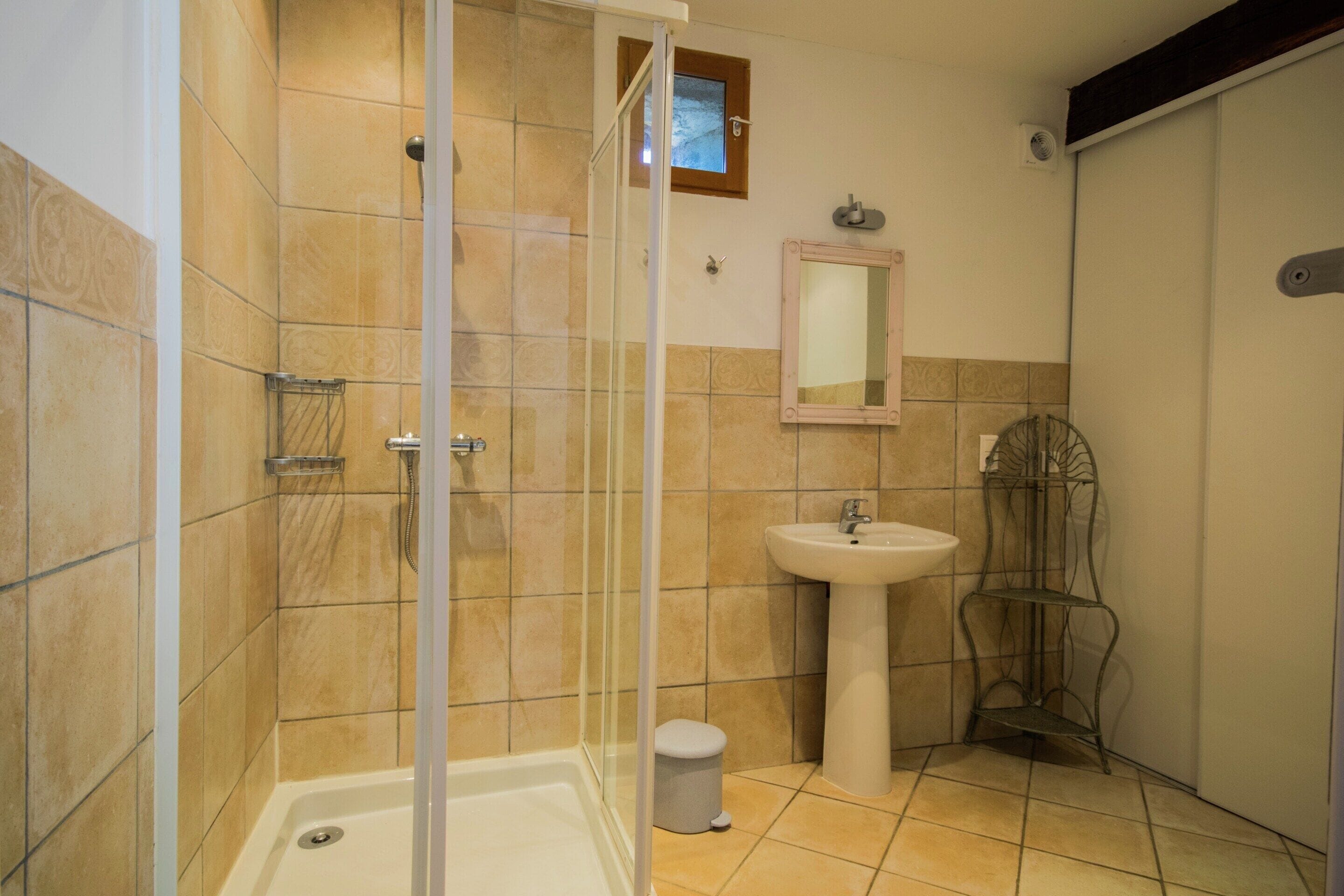 Een badkamer met een douche, wastafel en toilet.