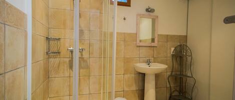 Een badkamer met een douche, wastafel en toilet.