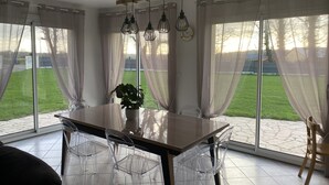 A dining area with a table, chairs, and a potted plant. - Holiday Home in Normandy Near the Sea (Etretat)