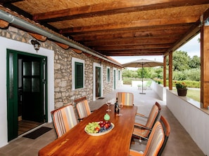Enjoy al fresco dining in a shaded outdoor space with a long table and six comfortable chairs.