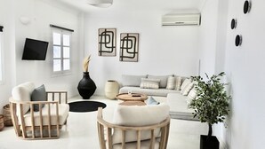 A modern living room with a sofa, two armchairs, a coffee table, and a potted plant. - Stunning BlueWhite Villa: Luxury Heated Infinity Pool Escape (Πύργος Καλλίστης)