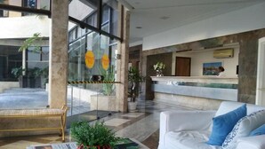 Eine moderne Lobby mit Empfangstresen, Sitzgelegenheiten und großen Fenstern.