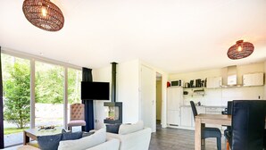 Ein modernes Wohnzimmer mit einer Couch, einem Flachbildfernseher und einem Kamin.