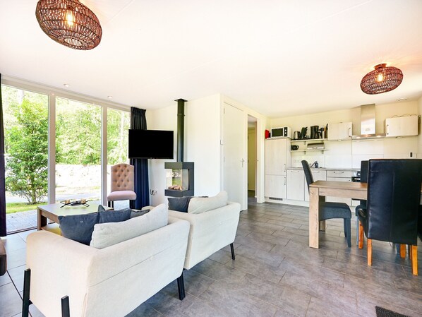 Ein modernes Wohnzimmer mit einer Couch, einem Flachbildfernseher und einem Kamin.