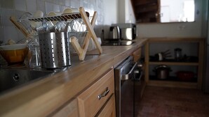 A kitchen with wooden cabinets, a stainless steel sink, and a dish rack. - GITE DE LA BRETAUDERIE 6/8 PEOPLE NEAR ANGERS (RIVES DU LOIR EN ANJOU)