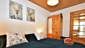 A bedroom with a bed, pillows, a wooden wardrobe, and two paintings on the wall. - Cozy Apartment in Rerik near Sea (Rerik)