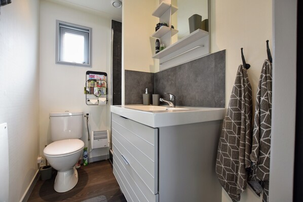 A compact bathroom with a toilet, a sink, and a towel rack. - Chalet With Balcony in Veluwe (Garderen)
