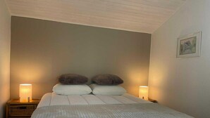 A bedroom with a large bed, two bedside lamps, and a framed picture on the wall. - Sunny Cottage With Pool (Yvoir)