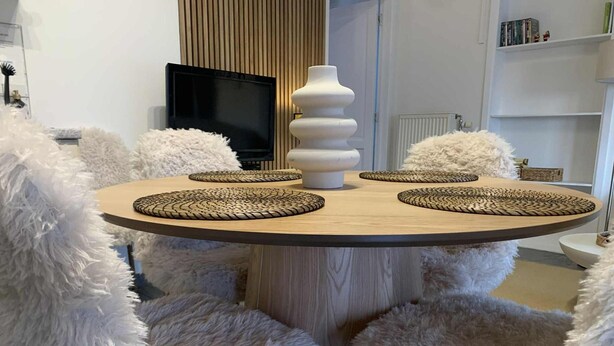 A round wooden table with woven placemats, surrounded by fluffy white chairs. - Sunny Cottage With Pool (Yvoir)
