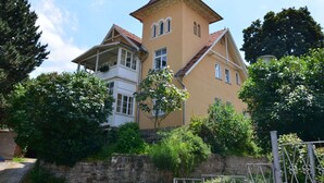 A two-story house with a steeply pitched roof and a tower-like structure. - Apartment in Harz Near Ski Slopes (Quedlinburg)