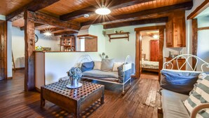 A rustic wooden interior with a bed, a sofa, a table, and a hanging light fixture. - Hideaway in Villeneuve-d'allier (Ally)