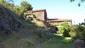 A stone building with a red-tiled roof, surrounded by greenery and a grassy area. - Hideaway in Villeneuve-d'allier (Ally)