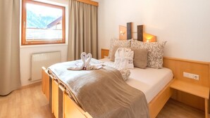 A hotel room with a bed, a window with curtains, a radiator, and a bedside table. - Beautiful Apartment in Langenfeld With Terrace (Laengenfeld)
