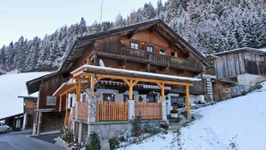 A wooden chalet with a balcony, surrounded by snow-covered trees. - Apartment in Kaltenbach Near Ski Lift (Kaltenbach)