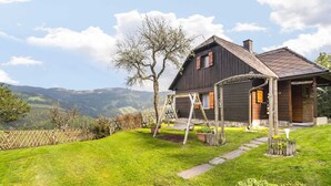 A wooden house with a porch and a swing set. - Chalet in Kalchberg Near Klippitztorl Ski (Bad Sankt Leonhard im Lavanttal)