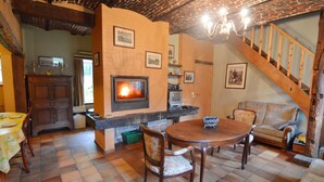 Ein gemütliches Wohnzimmer mit Kamin, Holzmöbeln und einer Treppe.