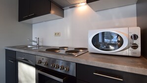 Une cuisine moderne équipée d’un four encastré, d’un four à micro-ondes et d’une cuisinière en acier inoxydable.