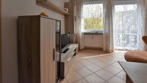 Eine moderne Küche mit eingebautem Backofen, einem Holzkorpus und einem Fenster mit Vorhängen.