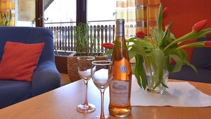 A table with a bottle of wine, two wine glasses, and a vase with tulips. - Quiet Apartment in Merlsheim With Balcony (Nieheim)