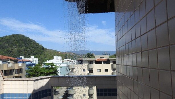 Vista de un edificio con fachada de azulejos y un elemento decorativo de agua.