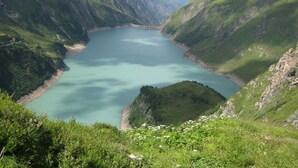 Paisagem montanhosa com um lago rodeado por vegetação exuberante.