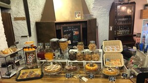 Une vitrine de boulangerie présentant diverses pâtisseries et des pots de confitures.