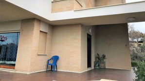 Un bâtiment moderne à deux étages, doté d’un toit plat, d’un balcon et d’un espace d’entrée abrité.