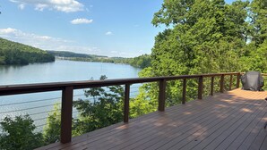 A wooden deck with a railing overlooking a lake, surrounded by trees. - Breathtaking Lake View w/Pool Nearby!- Knoxville/Oak Ridge (Knoxville)