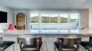 A kitchen with a large window, a red lamp, and a view of a lake. - Breathtaking Lake View w/Pool Nearby!- Knoxville/Oak Ridge (Knoxville)