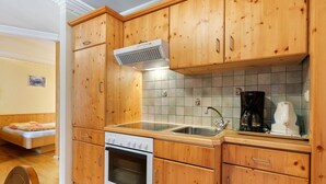 Une cuisine avec des meubles de rangement en bois, une cuisinière, un évier et une machine à café.