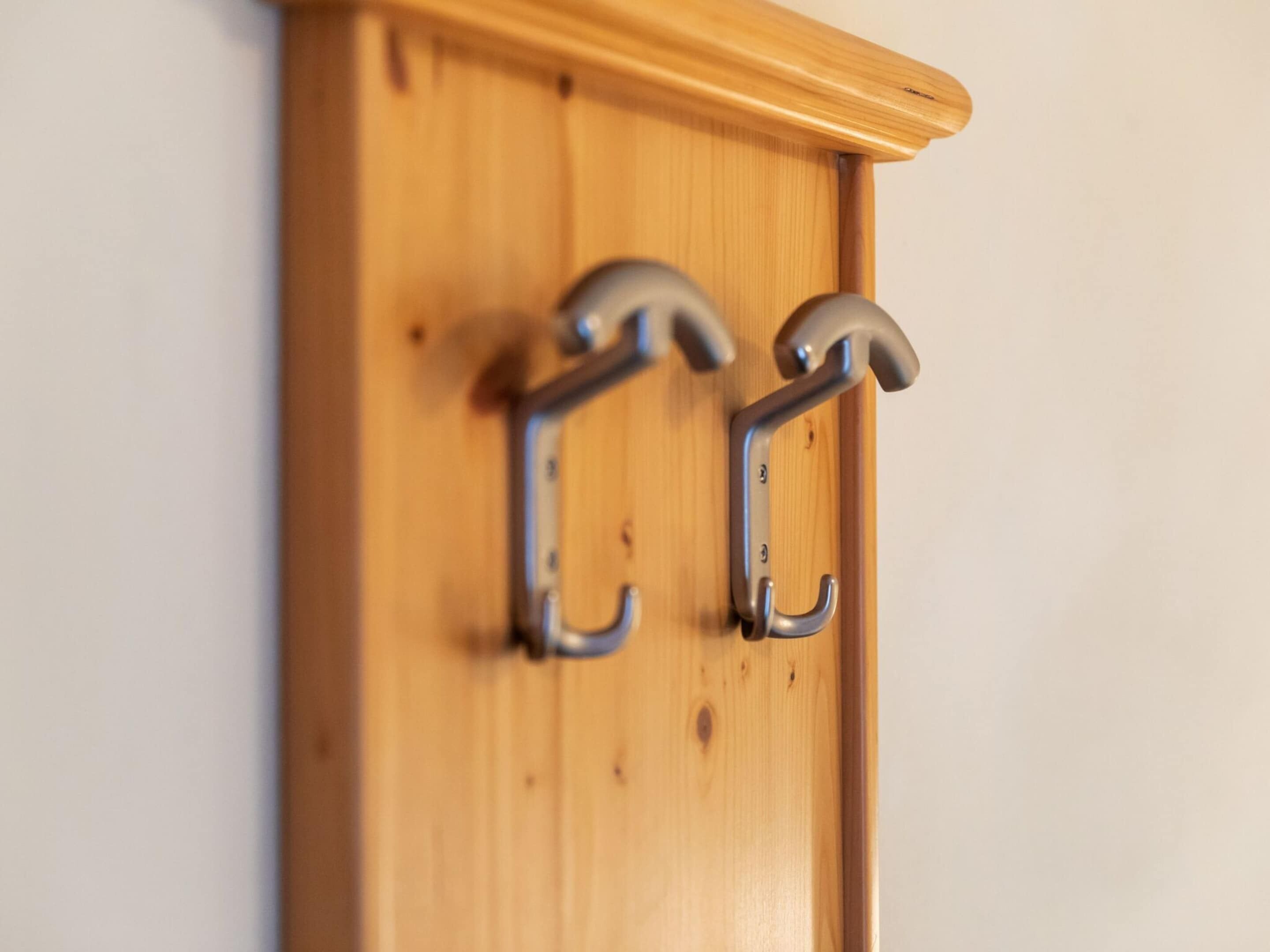 Una puerta de madera con dos ganchos metálicos.