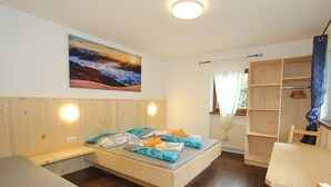 A cozy room with a bed, a desk, and a chair. There is a painting on the wall and a window with curtains. - Pleasant Apartment in Langenfeld With Sauna (Laengenfeld)