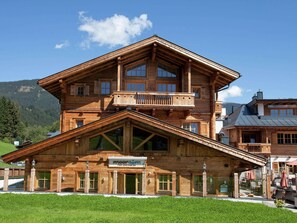 A large wooden chalet with a balcony, multiple windows, and a sign indicating it is a hotel. - Cozy Apartment with Sauna near Ski Slopes in Mittersill (Mittersill)