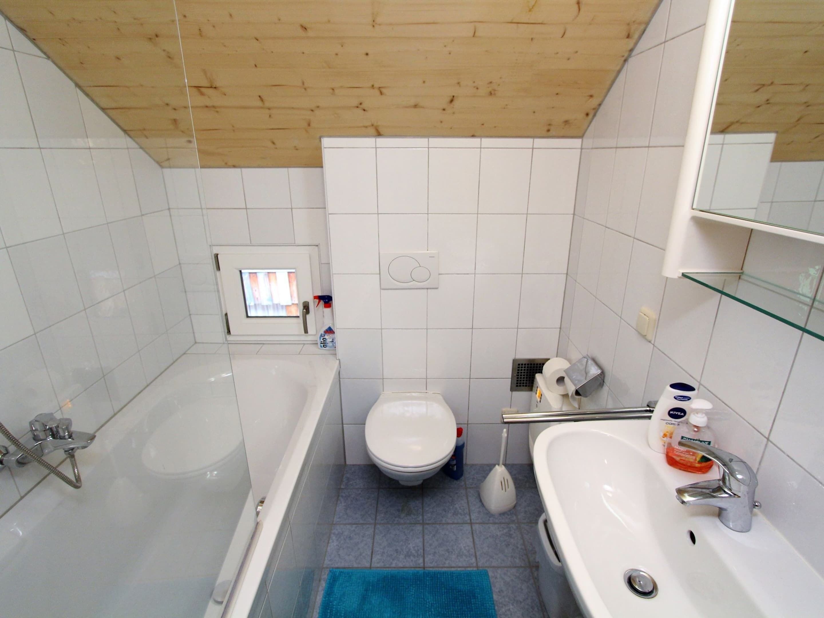 A bathroom with a bathtub, toilet, and sink.