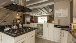 A modern kitchen with a central island, white cabinetry, and a stainless steel range hood. - Vintage Villa in Knokke-Heist near Beach (Knokke-Heist)