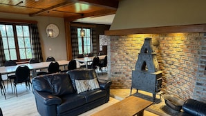 Un salon chaleureux avec un canapé en cuir, une table basse en bois et une cheminée en pierre.