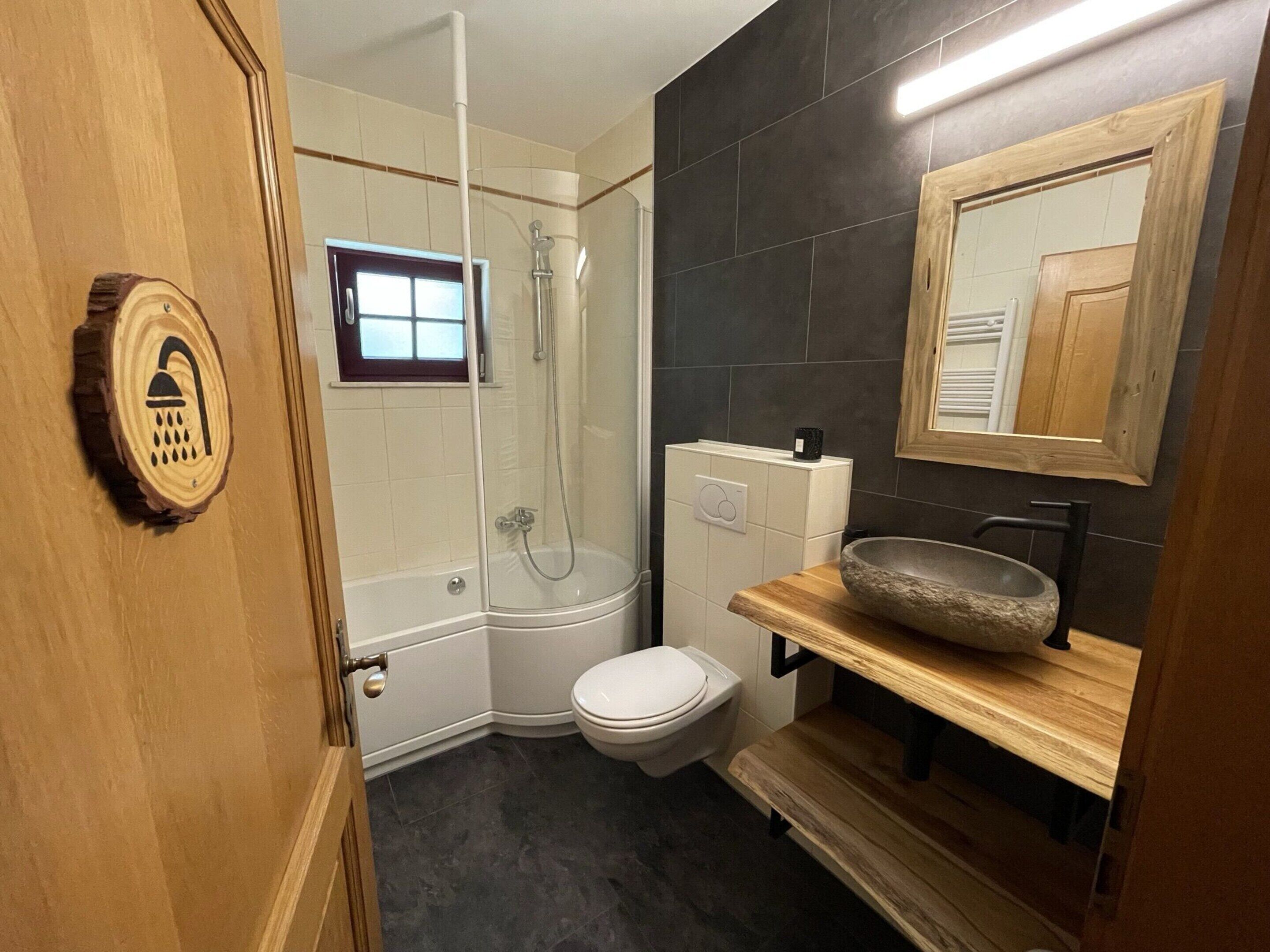 A bathroom with a shower, toilet, and sink.