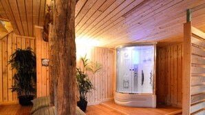 Ein Holzinnenraum mit Sauna, Holzbänken und Topfpflanzen.