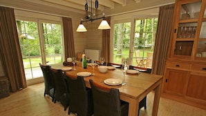 Comedor con una mesa de madera dispuesta para seis personas, rodeado de sillas de mimbre.