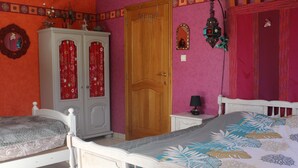 Ein Schlafzimmer mit zwei Betten, einem Kleiderschrank und einer Tür.