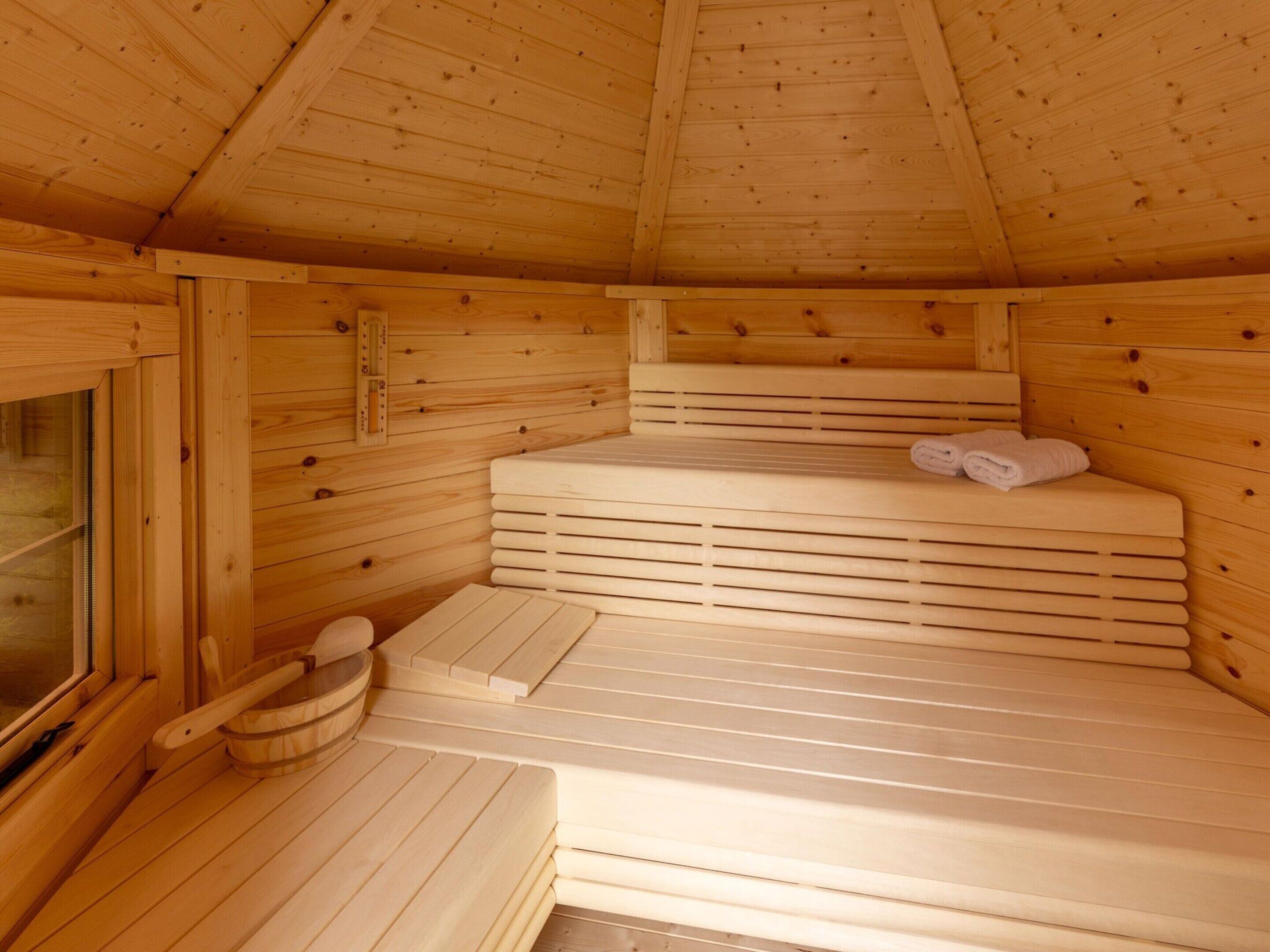 Uma sauna de madeira com bancos e uma janela.