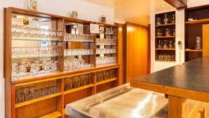 A bar area with shelves of glassware and a metal counter.