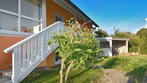 A house with a white staircase leading to a balcony, a small garden, and a shed in the backyard. - Fantastic Holiday Home in Schonsee, Bavaria (Schoensee)